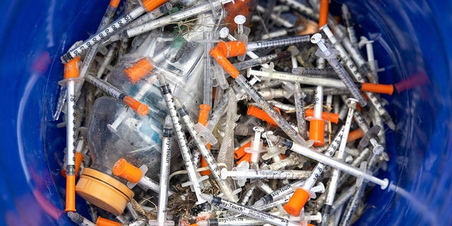 This file image shows heroin syringes fill a bucket after volunteers collected them at a homeless encampment on March 1, 2022 in Seattle, Washington.