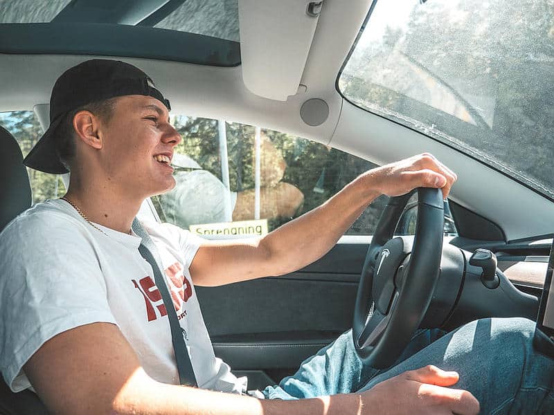 man with cap driving car